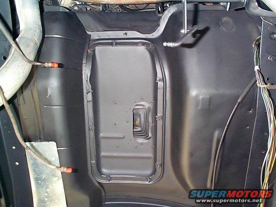 Underside of a vehicle showing the floor pan and exhaust pipe. Wires are visible on the right