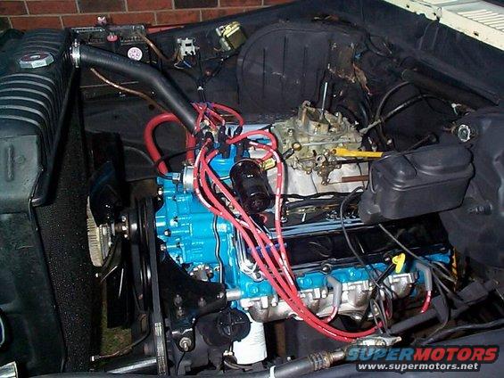 Engine bay with blue engine block and red spark plug wires