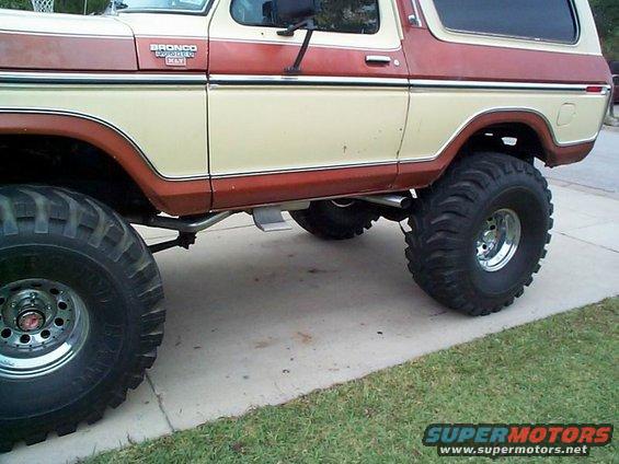 Side view of a lifted 1979 Ford Bronco with two-tone paint and large tires