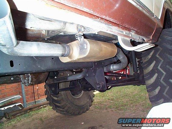Undercarriage view of a custom exhaust system on a lifted vehicle with large tires