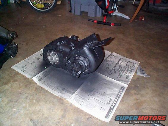 Black transfer case on newspaper, with spray paint