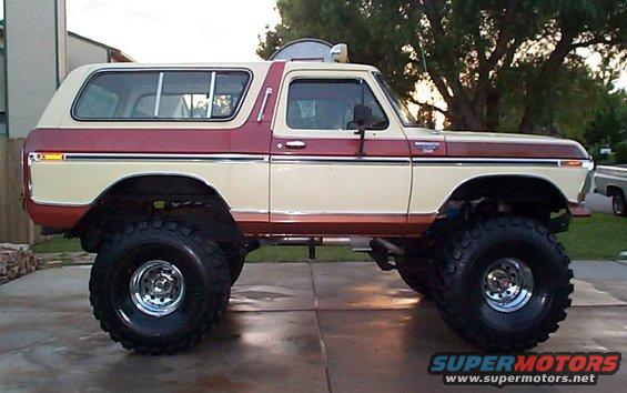 Two-tone red and cream lifted Ford Bronco with large off-road tires