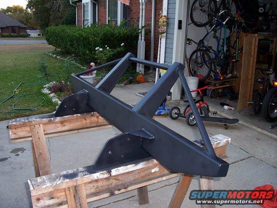 Custom steel bumper on sawhorses in front of a garage