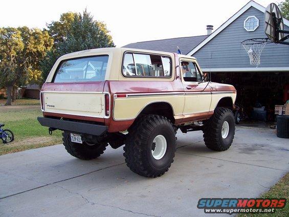 1979 Ford Bronco with large off-road tires and lifted suspension, parked in a driveway