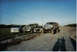 2000 Ford Excursion - Several vehicles are parked on a dirt road under a clear blue sky.