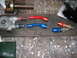 1997 Ford Crown Victoria - Various automotive fluid fittings are laid out on a workbench, including an oil filter housing and several colored AN adapters.