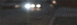 1995 Chevrolet Impala - Headlights of a vehicle are visible at night, with blurred lights in the distance.