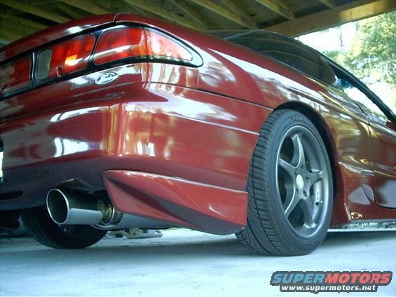 Red 1995 Ford Probe rear quarter panel with aftermarket exhaust and alloy wheel
