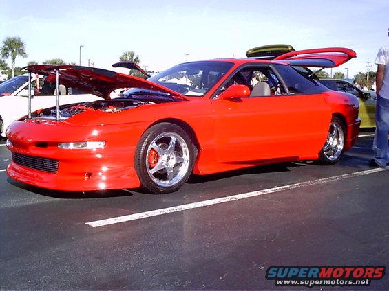 Red 1995 Ford Probe with hood and trunk open, parked in a lot