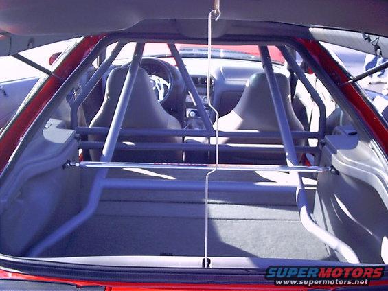 Interior view of a 1995 Ford Probe with a roll cage installed, showing the front seats and dashboard