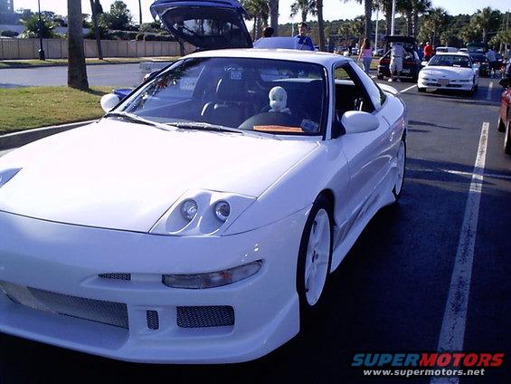 White 1995 Ford Probe 3q-front view with pop-up headlights and a doll driver