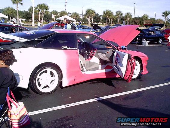 Pink and white coupe with doors open, custom interior