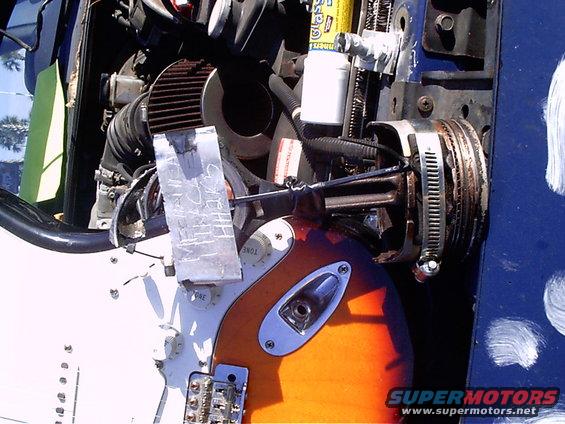 Engine components and an electric guitar body with sunburst finish, held together with tape and clamps