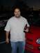 1996 Ford Probe - A man stands next to a red Dodge SRT-4 in a parking lot at dusk.