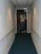 1996 Ford Probe - A man stands in a doorway at the end of a carpeted hallway with handrails on the walls.