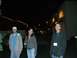 1996 Ford Probe - Three individuals are captured in a nighttime scene outside a lit building.