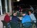 1996 Ford Probe - A group of men are gathered around tables outdoors at night, with some laughing and interacting.