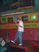 1996 Ford Probe - A man performs on stage in a themed entertainment venue with frog imagery and humorous signs.