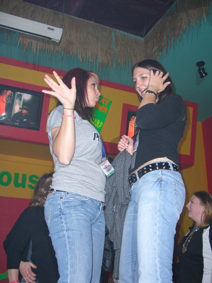 Two women talking in a room with colorful walls and a TV screen