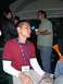 1996 Ford Probe - Attendees mingle at an indoor event, with one man holding a digital camera.