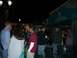 1996 Ford Probe - People socialize outside a daiquiri bar at night, illuminated by string lights and lamps.
