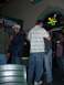 1996 Ford Probe - A group of people are seen socializing in a dimly lit establishment, with a neon Heineken sign visible in the background.