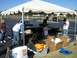 1996 Ford Probe - A white sports car is visible in the background behind a tent where people are gathered.