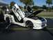 1996 Ford Probe - This heavily modified white sports car features custom graphics, butterfly doors, and an exposed engine bay.