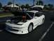 1996 Ford Probe - A white 1996 Ford Probe is displayed with its hood and trunk open, revealing the engine compartment.