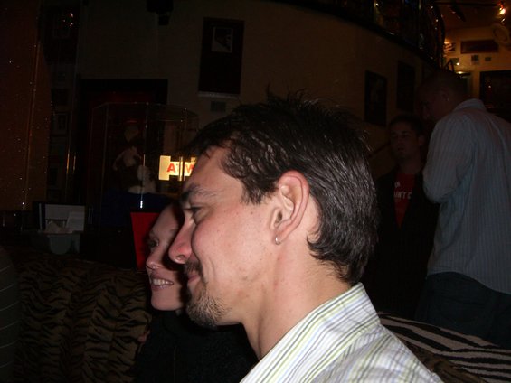 Man in striped shirt and woman in foreground, other people in background
