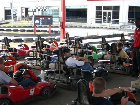 Go-karts lined up at a track, with drivers seated