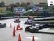 1996 Ford Probe - Go-karts navigate a track with various advertisements visible in the background.