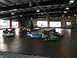 1996 Ford Probe - Several go-karts are in motion on an indoor track, with drivers focused on the race.