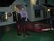 1996 Ford Probe - A man poses atop a dinosaur statue outside a shop at night.