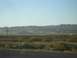 1996 Ford Probe - A wide view of a desert landscape mountains in the distance, railroad tracks, and sparse vegetation under a clear blue sky.