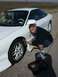 1996 Ford Probe - Man inspects the fender of a white 1996 Ford Probe, with a toolbox nearby.