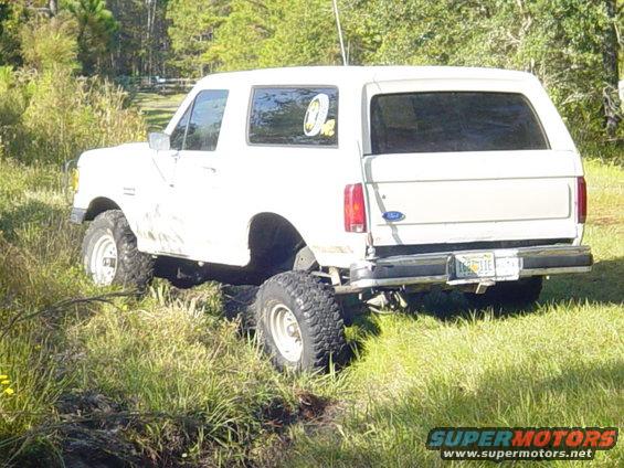 White 1989 Ford Bronco rear 3/4 view in grassy field