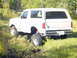 1989 Ford Bronco - This 1989 Ford Bronco is seen from the rear 3/4 angle in a grassy outdoor setting.