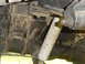 1989 Ford Bronco - Undercarriage view showing the rear suspension system, including leaf springs and a shock absorber.