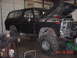 1978 Ford Bronco - A black 1978 Ford Bronco is shown with its hood up, revealing the engine bay, in a garage setting.