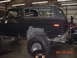 1978 Ford Bronco - This black Ford Bronco is parked inside a garage, showing off its large off-road tires and some bodywork in progress.