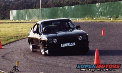 Black coupe with license plate FB-EJ 587 on a race track with orange cones