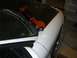 1996 Ford Probe - An orange coilover suspension part is placed on the hood of a white car, obscuring the windshield.