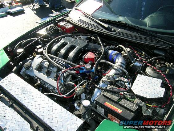 Engine bay showing intake manifold, battery, and custom wiring. SuperMotors logo visible
