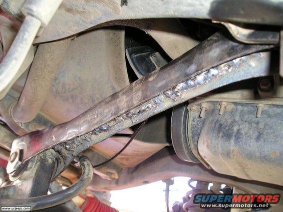 Close-up of a welded suspension arm on a vehicle's undercarriage
