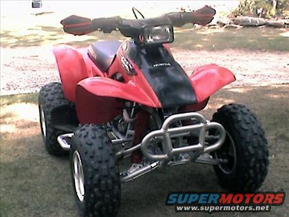 Red ATV with black front panel and silver bumper. Honda logo visible on front