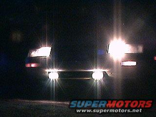 Car headlights illuminated at night, front view