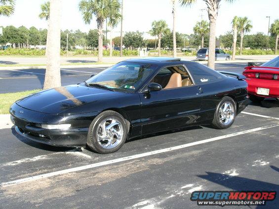 Black 1993 Ford Probe parked in a lot next to a red car