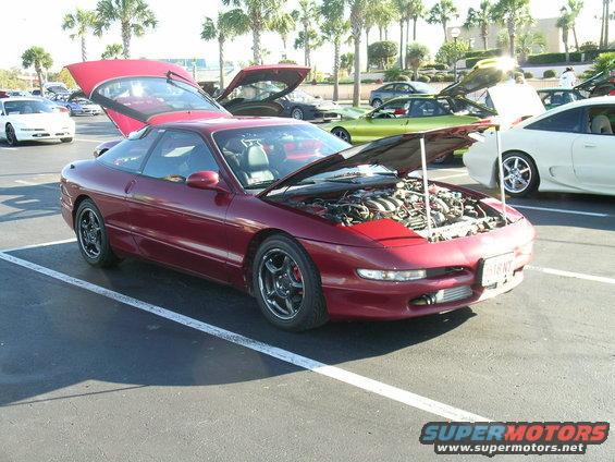 Red 1993 Ford Probe coupe with hood and trunk open, parked in a lot
