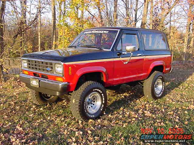 Red and black Ford Bronco II with gold stripe, seen from a 3/4 front angle